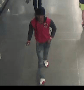 subject in red hoodie and jeans walking