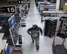 burglary suspect in dark coat and mask inside Ace Hardware
