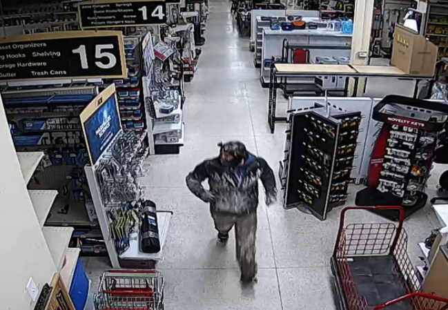 burglary suspect in dark coat and mask inside Ace Hardware